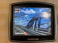 Front of TomTom GPS powered on showing startup screen