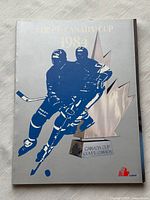 Front cover showing title, year, player silhouettes and trophy graphic