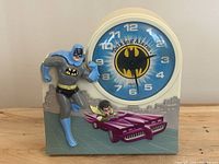 Front view showing Batman figure, Robin in car and clock face