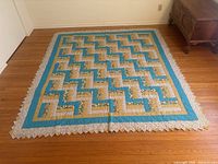Full view of quilt laid flat showing zig-zag pattern and border