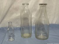 Three milk bottles side by side showing sizes and shapes