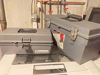 Two grey plastic tool boxes, one labelled Benchmaster
