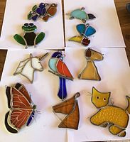 Group shot of all ten stained glass suncatchers laid on white background