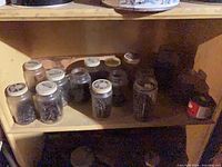 Glass jars on shelf containing assorted fasteners