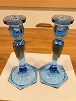 Full view of both blue glass candlesticks front angle