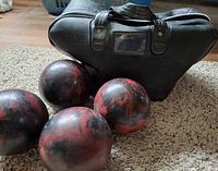 Bag front with four candlepin balls on rug