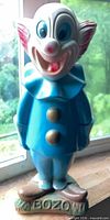 Front view of blue Bozo the Clown bank standing on BOZO base