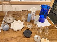 Overall view of vases, hurricane chimneys, candle accessories on tabletop