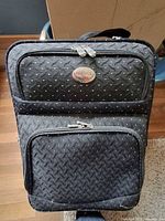 Front view of Bellavia suitcase showing logo badge and two front zip compartments