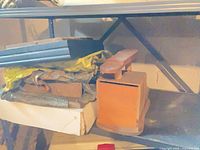 Stack of photo frames and wooden shoe shine box on shelf