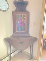Corner hutch sitting on drop-leaf table showing full lot