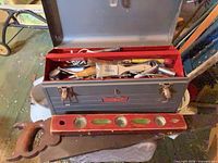 Craftsman toolbox open showing contents, level and hand saws in foreground
