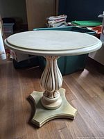 Full view of round cream pedestal end table