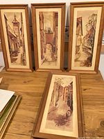 Four framed prints displayed together on table