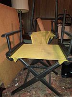Two unfolded director chairs showing black frames and yellow canvas seats
