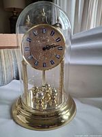 Full view of Hamilton glass-domed mantel clock showing base, pillars, dial and pendulum