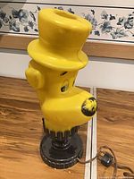 Full view of yellow Huckleberry Hound bust lamp on base with cord visible