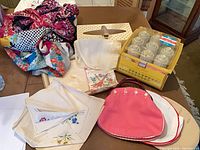 Group view of all items including scarves, hankies, tissue box cover, hot roller set, Bermuda bag with covers