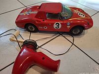 side view of red race car with generator remote