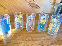 Five McDonald’s character glasses arranged side by side showing full graphics