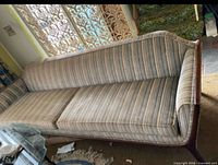 Full view of striped sofa from front showing wood base and cushions