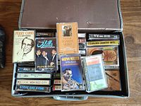 Open travel case showing assorted prerecorded cassettes including Perry Como, The Mills Brothers, Frank Sinatra, Glenn Miller etc.