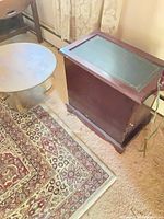 End table with inset top next to round table