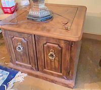 Front view of one end table showing cabinet doors and hardware