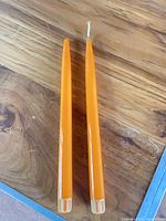 Top view showing two orange taper candles, one with wick insert