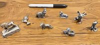 Group shot of all eight pewter animal figurines with Sharpie for scale
