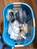 Laundry basket containing Vornado fan and assorted small packaged items
