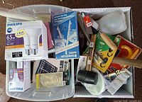 Mixed contents in storage bin including Philips LED bulbs, hardware, hand tools