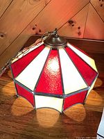 Side view of stained glass swag light showing red and white panels and chain