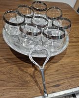 Eight silver-rim glasses arranged on silver-tone pedestal tray, handle detached, overall view of lot