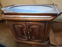 Side table cabinet with framed mirror resting on top