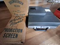 Brumberger slide viewer box beside gray slide projector