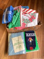 Box containing assorted folded linens and packaged items