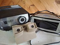 Front view showing View-Master projector lens, Emerson clock and hand viewer