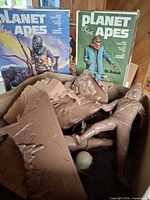 Front view of two Planet of the Apes model kit boxes and loose tan parts
