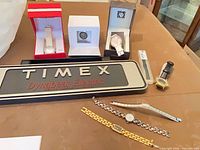 Full lot overview including Timex sign, boxed watches, additional loose watches and band