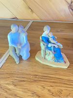 Both figurines side by side on wooden surface