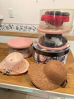 Group view of hats and round/clear hat boxes on table