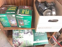 Shelf with two Reactor boxes, one Emerald box, and plastic bin of loose solar light parts