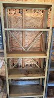 full frontal view of assembled beige metal shelving unit with five shelves