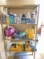 Full shelving view with assorted cleaners, paper goods, trash bags