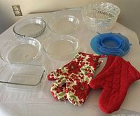 Overview of glass pie plates, loaf pan, plastic bowl, silicone lids, oven mitts