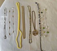 All eight necklaces laid out side by side on surface