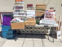Wide shot of entire lot on table: ornaments, storage totes, bins, wreath, gift bags