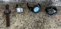 All four watches side by side on countertop