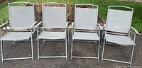 Front view of four gray metal folding patio chairs side by side